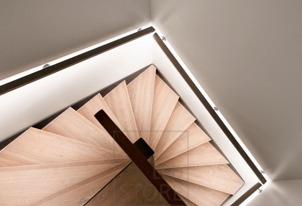 Led ribbon on a staircase handrail, facing downwards. Illuminating indirect light on the staircase in a soft and atmospheric way. Ledstore.fi