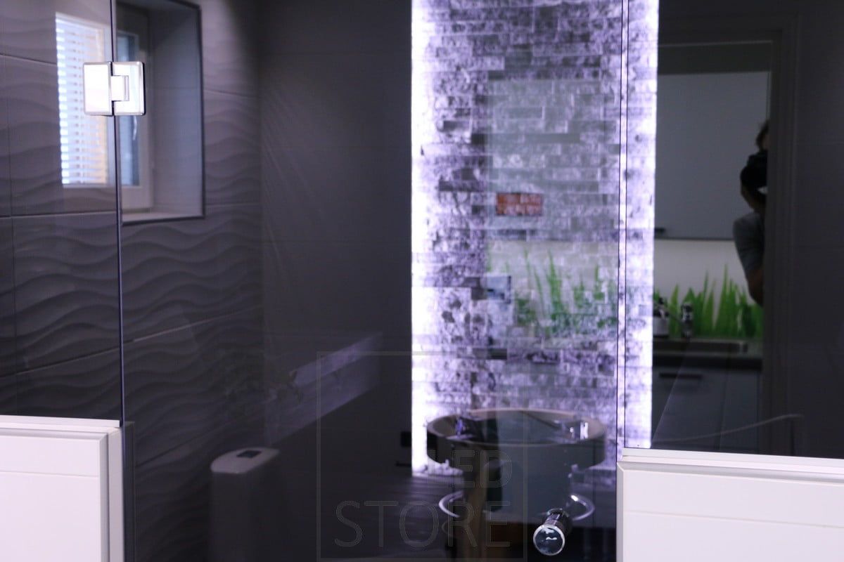 Highlighting details with the help of an LED ribbon. Led strips upright on both sides of the wall, highlighting the beautiful stone wall behind the stove. Ledstore.fi