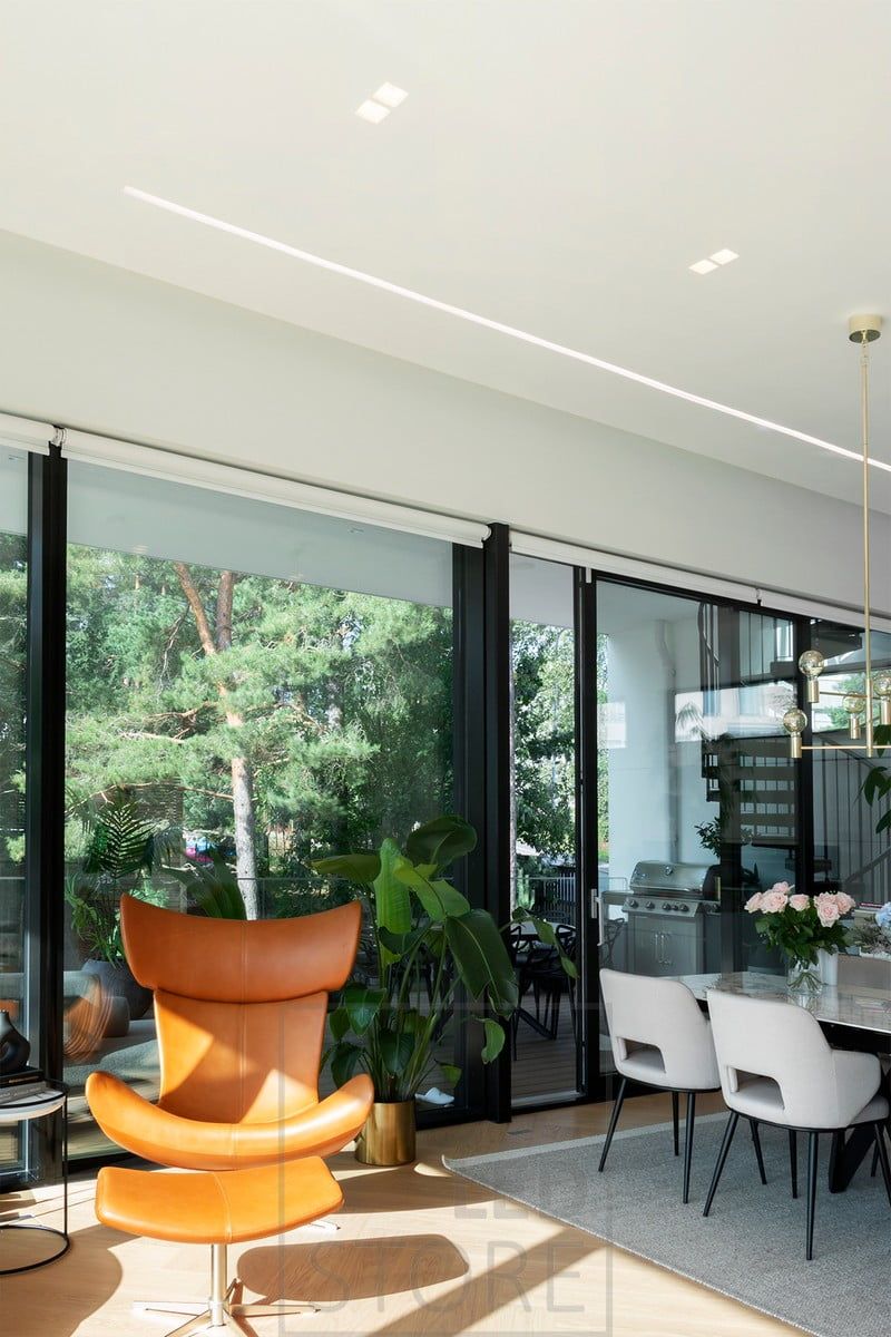 A wide flush-mounted profile in the living room and open kitchen creates a beautiful, well-lit line of light next to the window. Ledstore.fi