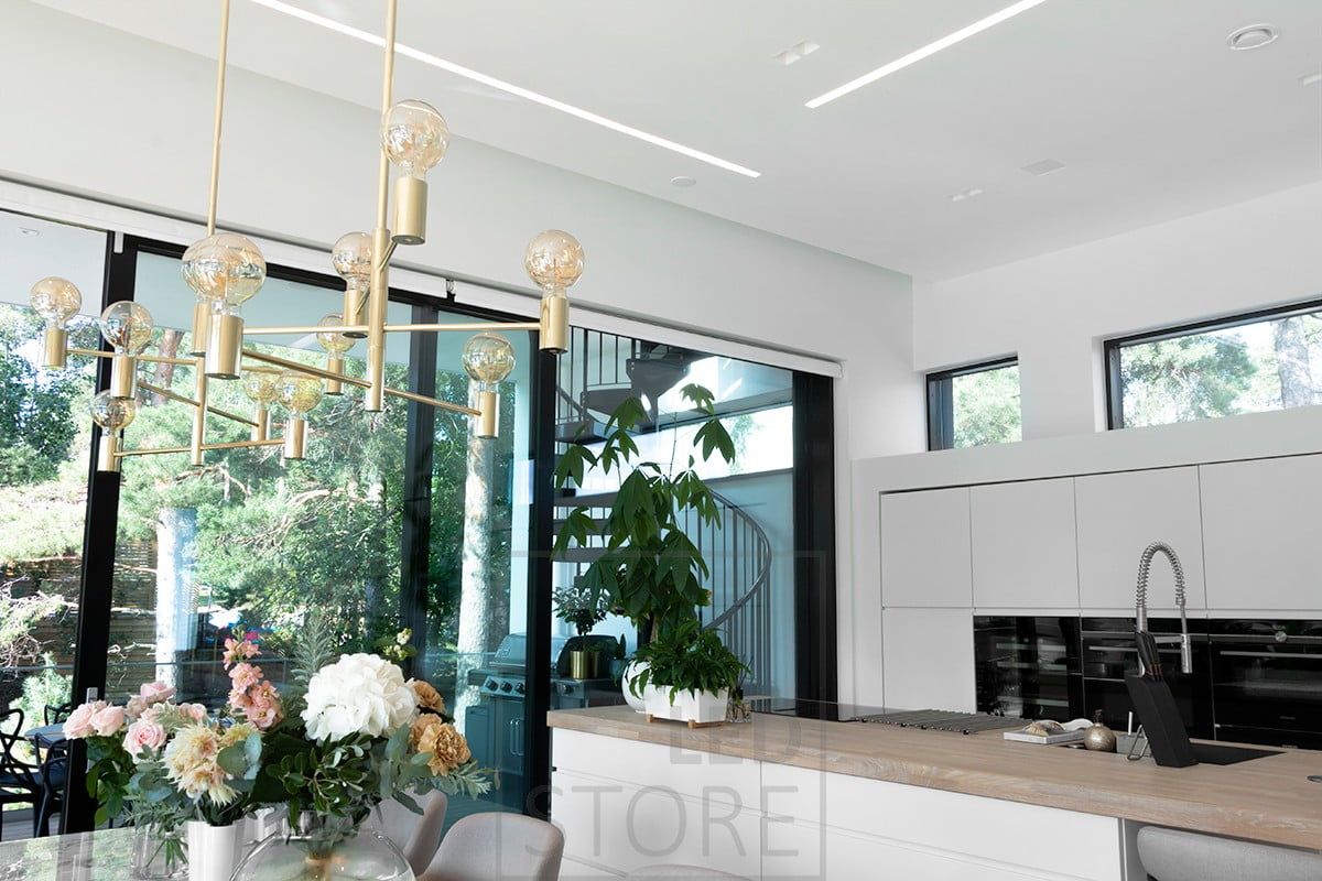 Wide flush-mounted profiles in the living room and open kitchen create beautiful, well-lit lines of light. Ledstore.fi