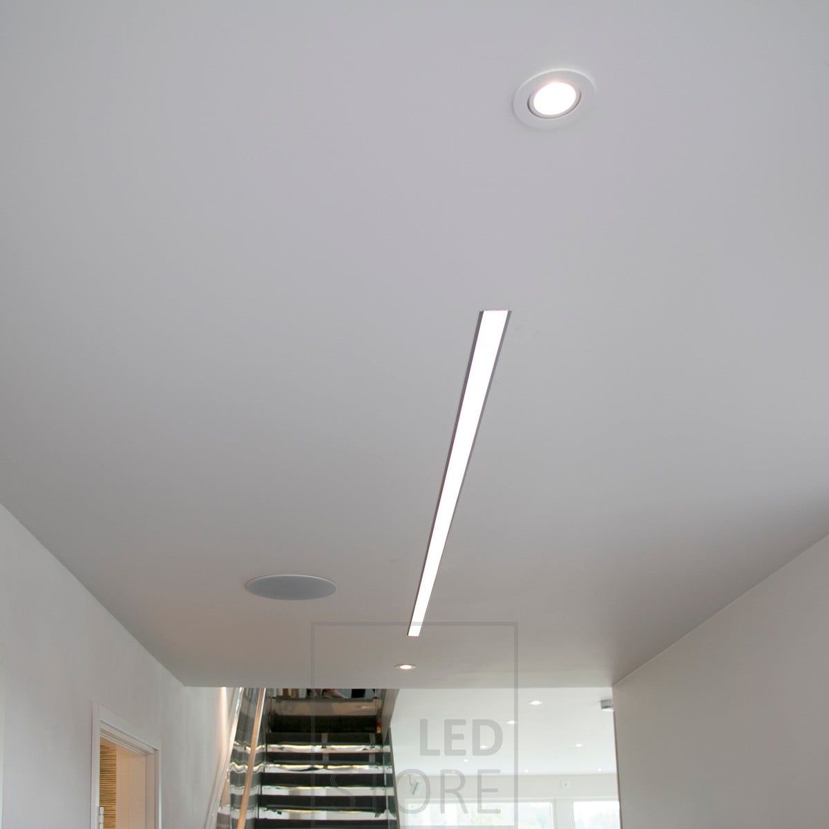 A wide flush-mounted profile creating an effectively illuminating light line in a corridor. Ledstore.fi