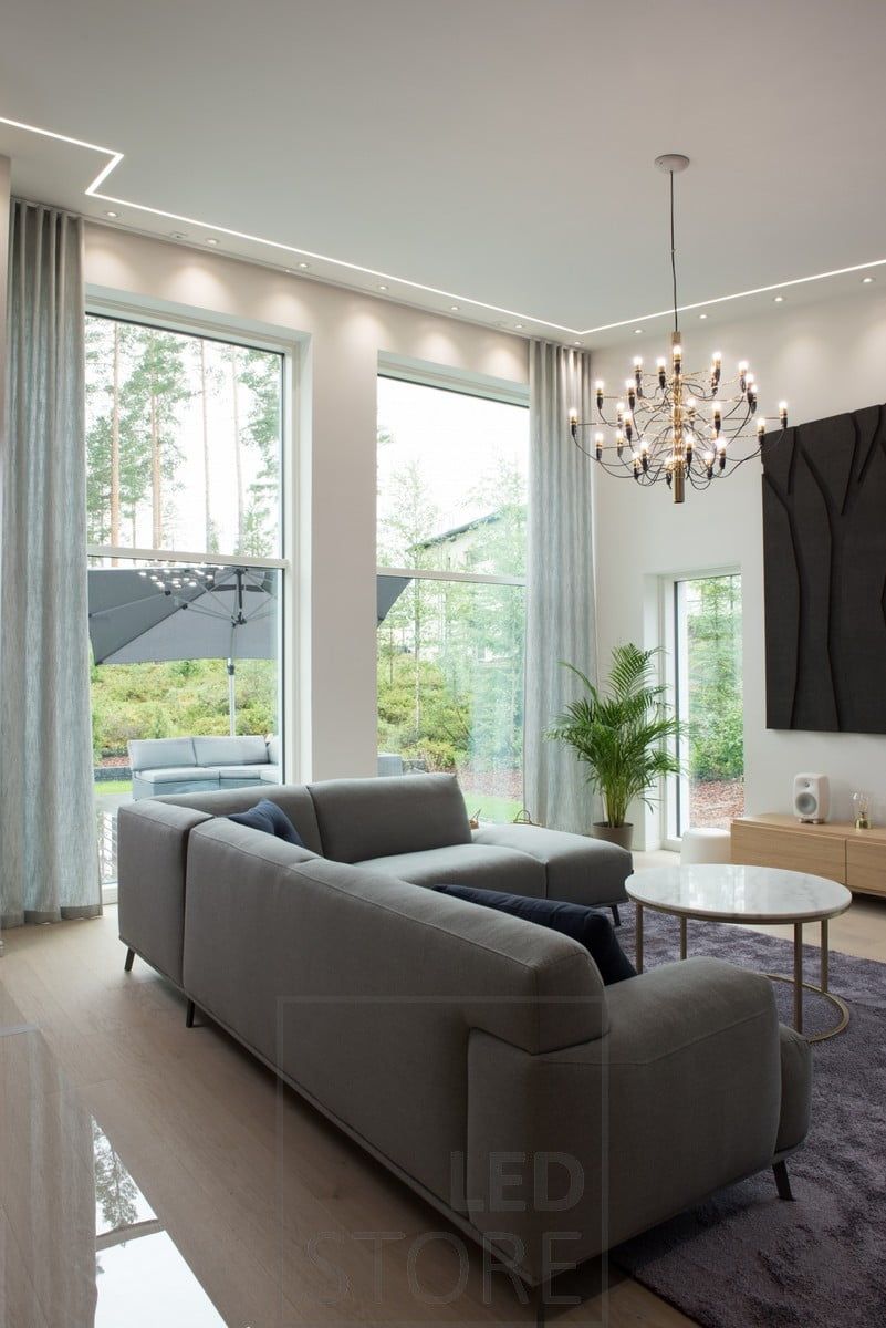 In the living room, a circulating LED strip light in a narrow upholstered profile and small, atmospheric spots. Ledstore.fi