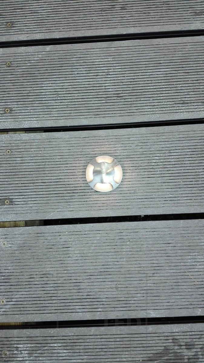 Four-way illuminated outdoor spotlight, embedded in a terrace. Soft mood lighting outside. Ledstore.fi