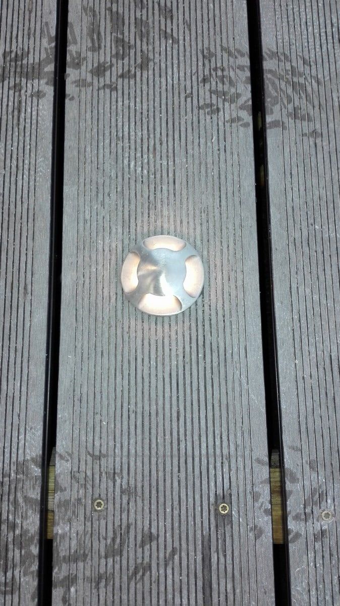 A four-way illuminated patio spotlight creating soft, indirect light outside. Ledstore.fi