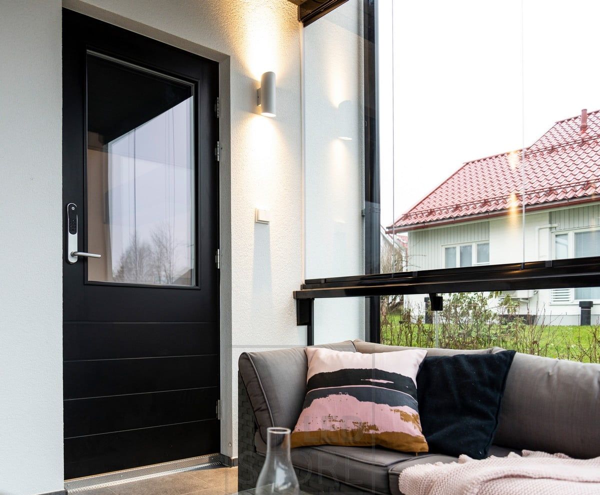 White Viisto wall light next to the entrance. The luminaire illuminates the wall in two directions with a warm and soft 3000K light. Ledstore.fi
