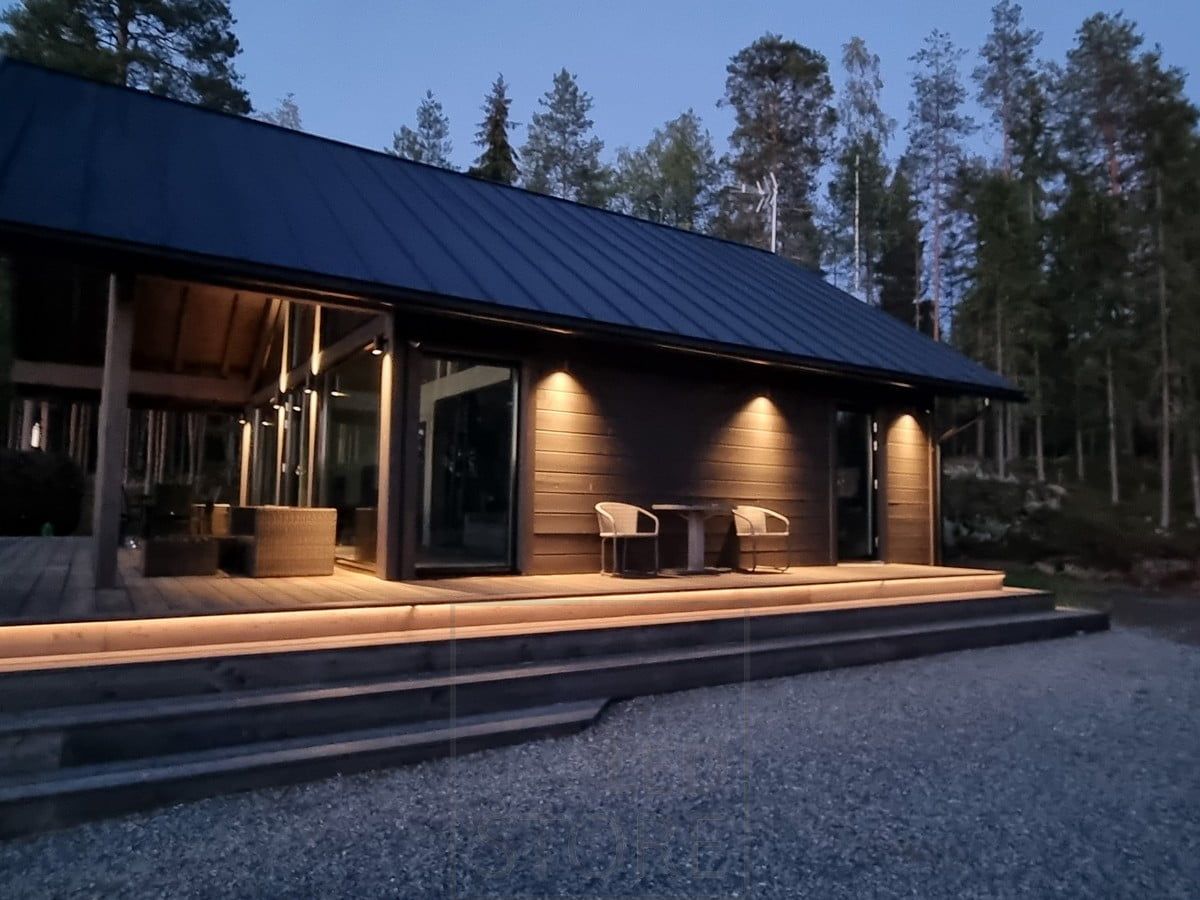 Exterior lighting on the staircase with indirect light, accentuating the high space with bi-directional wall lights. The lower side is illuminated by one-way versions of the same luminaire. Ledstore.fi