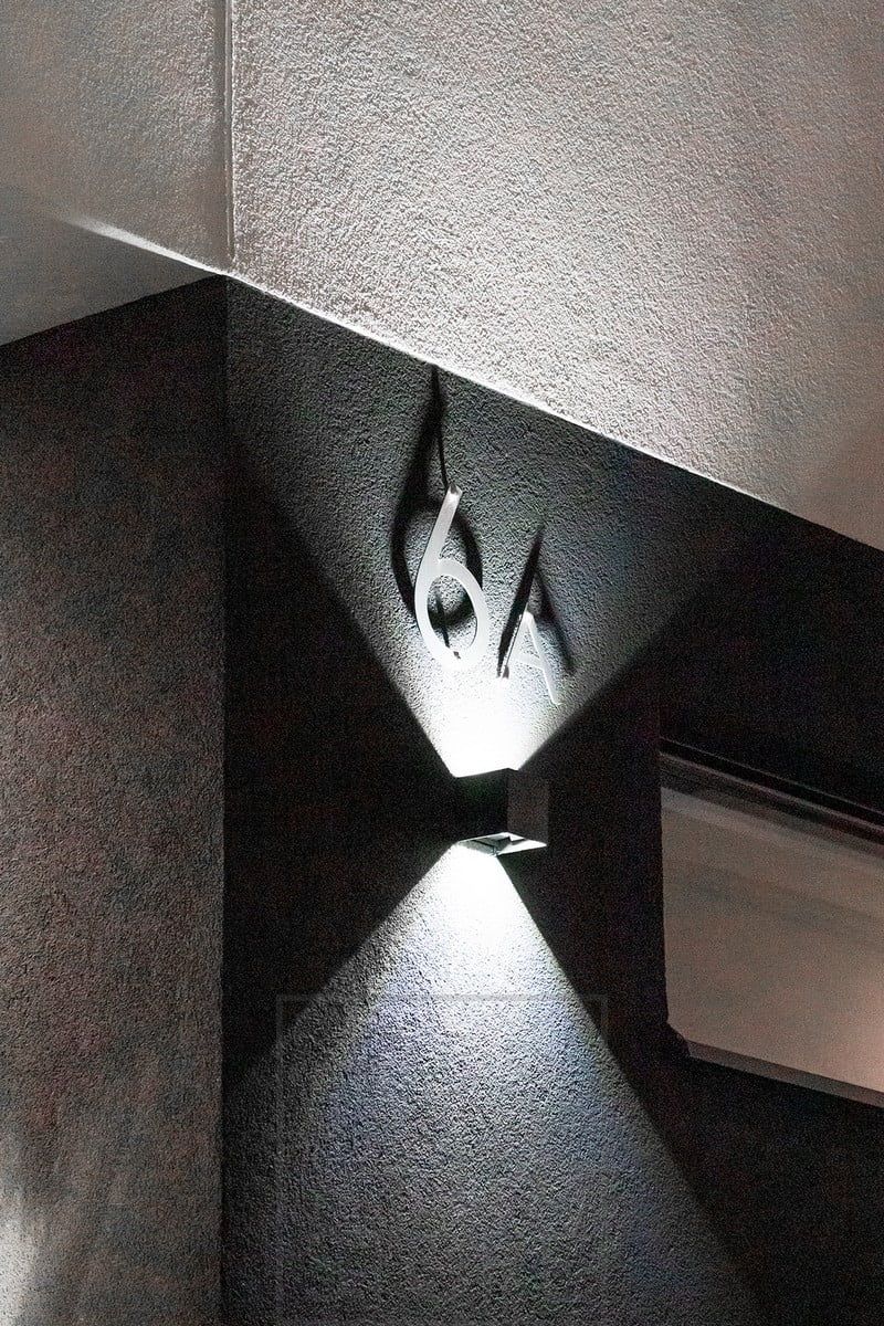 FUNK wall light illuminating the house number and facade. The opening angle of the light can be adjusted to suit your needs by means of four separate wings. Ledstore.fi