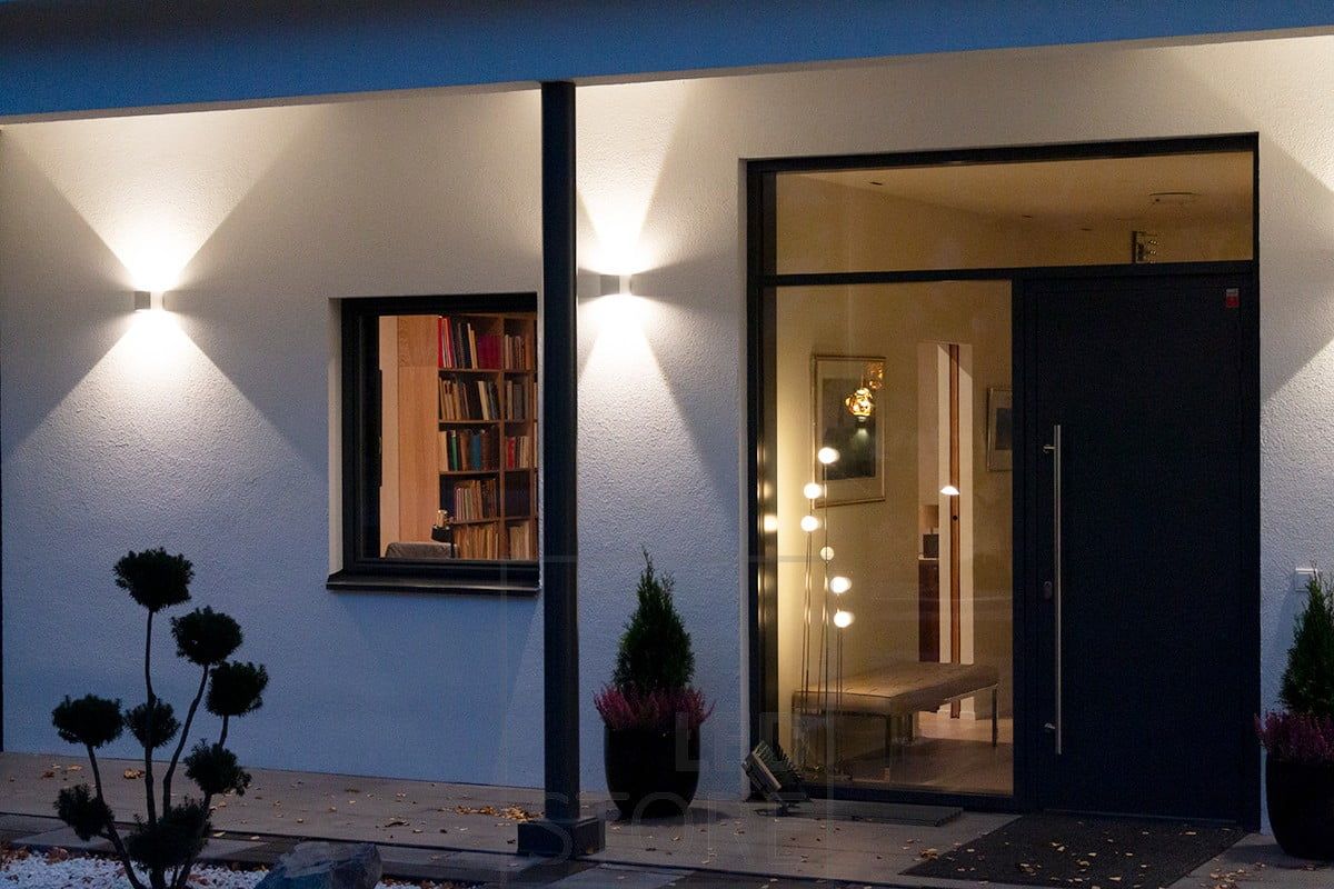 White, bi-directional FUNK wall lights illuminating the façade and entrance. Ledstore.fi