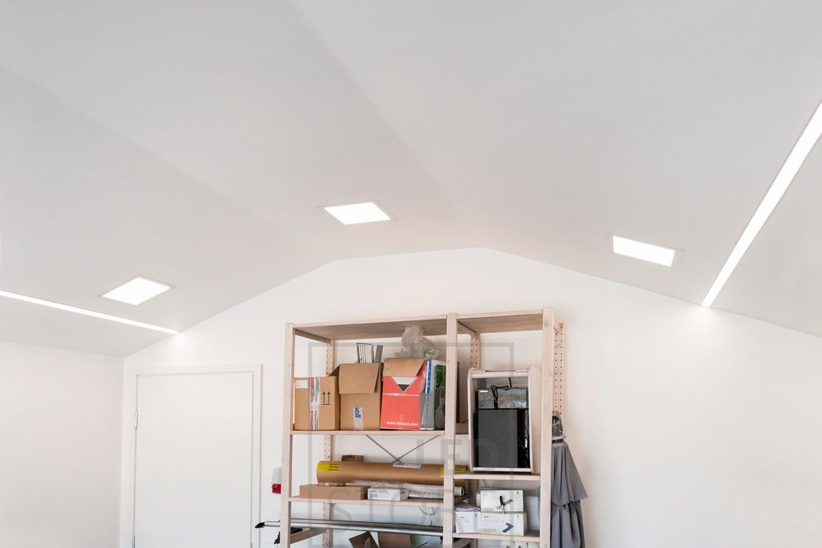 Recessed panel luminaires combined with wide recessed profiles on the sides of the room. Ledstore.fi