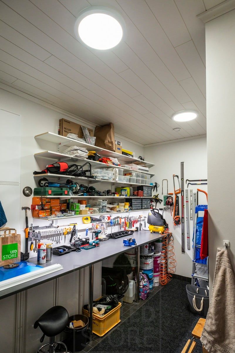 A workstation in a warehouse with large ceiling lights on the ceiling. Ledstore.fi