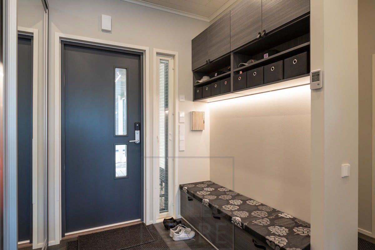 At the entrance to the hallway, above the bench, an LED strip in a low profile surface. Ledstore.fi