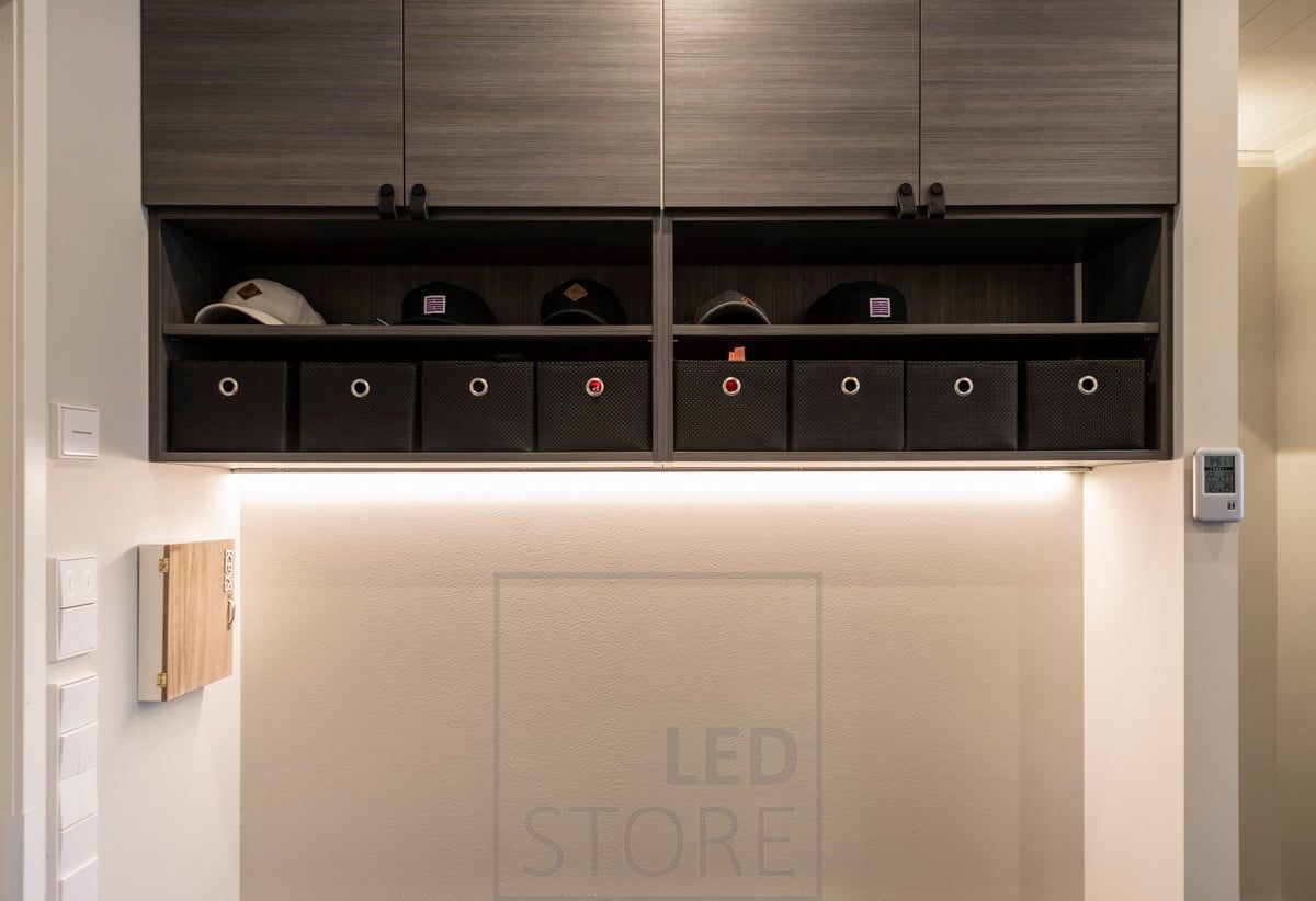 At the bottom of the upper cabinet in the hallway, an LED strip in a low profile surface indirectly illuminates the ambient light. Ledstore.fi