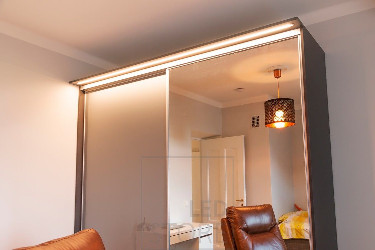 Led ribbon in a narrow flush profile in a box built on top of a cabinet. The light illuminates well the hallway and the cabinet and its contents. Ledstore.fi