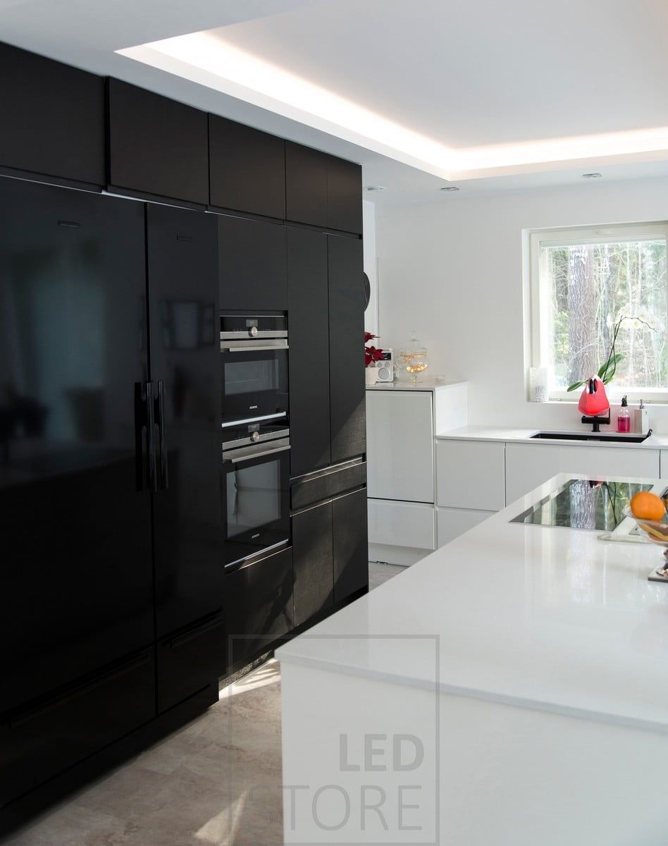 In the kitchen, a light ceiling, led strip creating indirect light from a specially created shelf. Ledstore.fi
