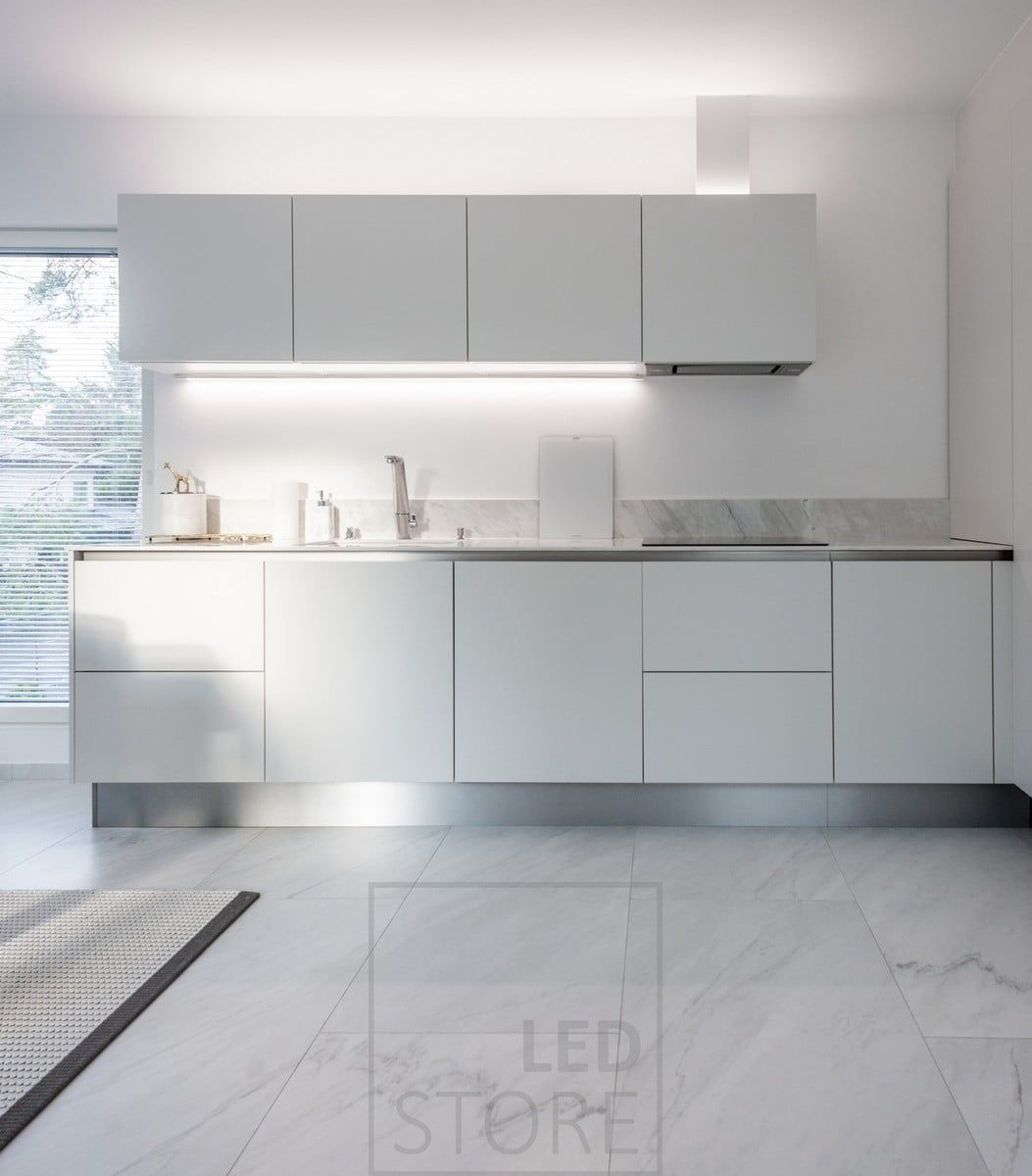 In the kitchen, a countertop led strip attached to the bottom of a cabinet and another led strip providing indirect light on top of the cabinets. Ledstore.fi