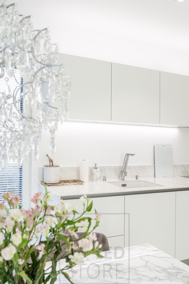 Kitchen illuminated with led strips under and on top of the upper cabinet. Ledstore.fi