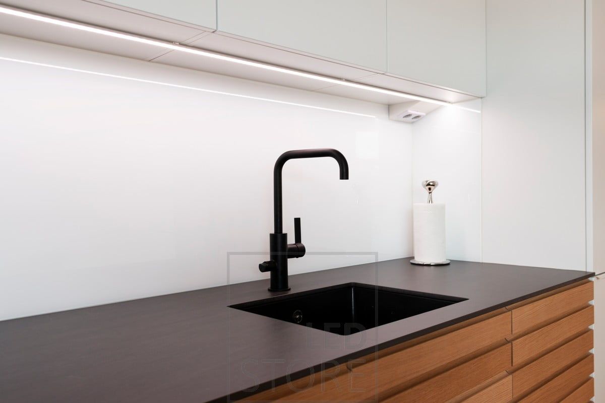 LED strip light in the middle of the cabinets in a low profile surface profile as a worktop light. Ledstorfe.fi