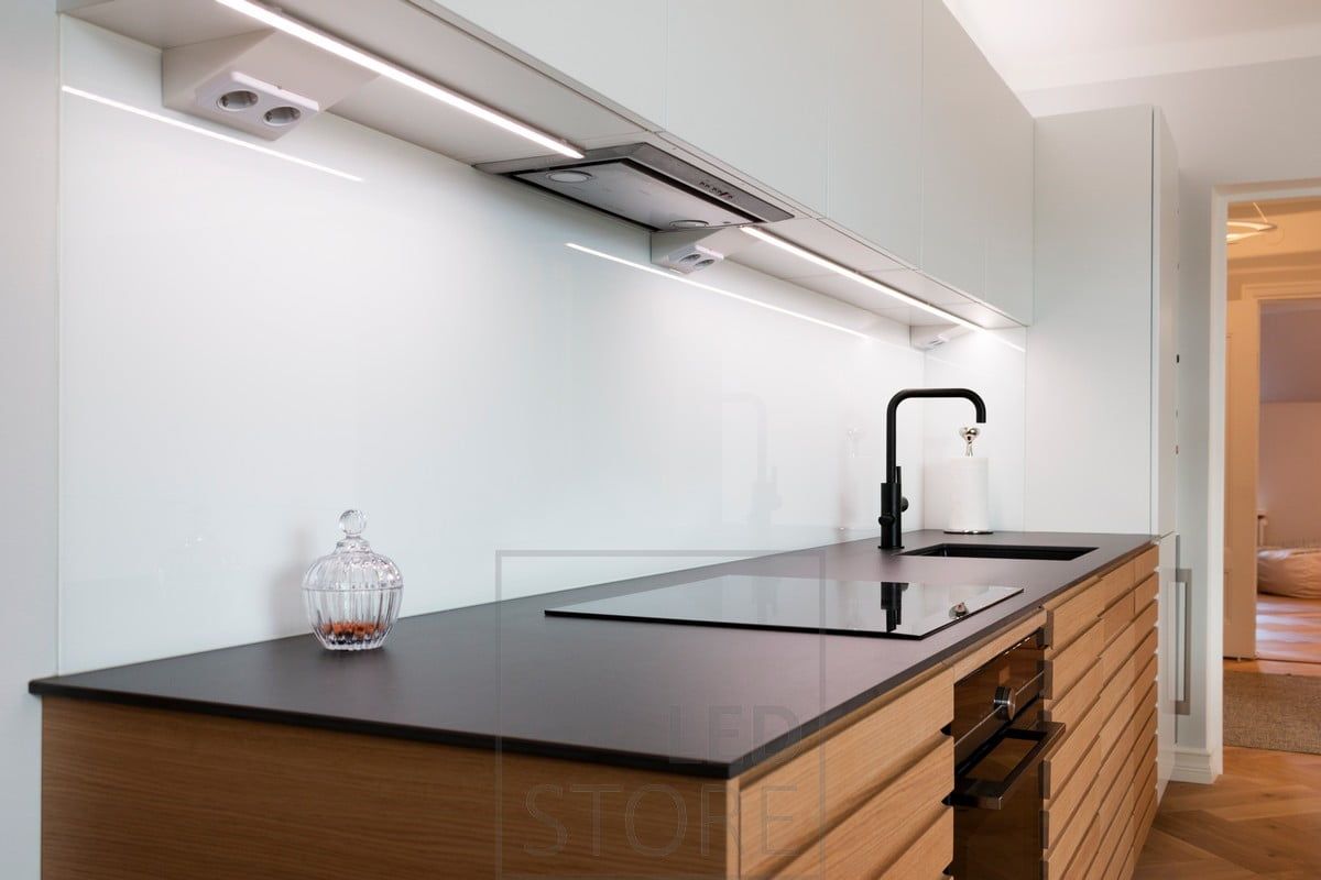 LED profile mounted in the middle of the base of the upper cabinets illuminating the worktop. Ledstore.fi