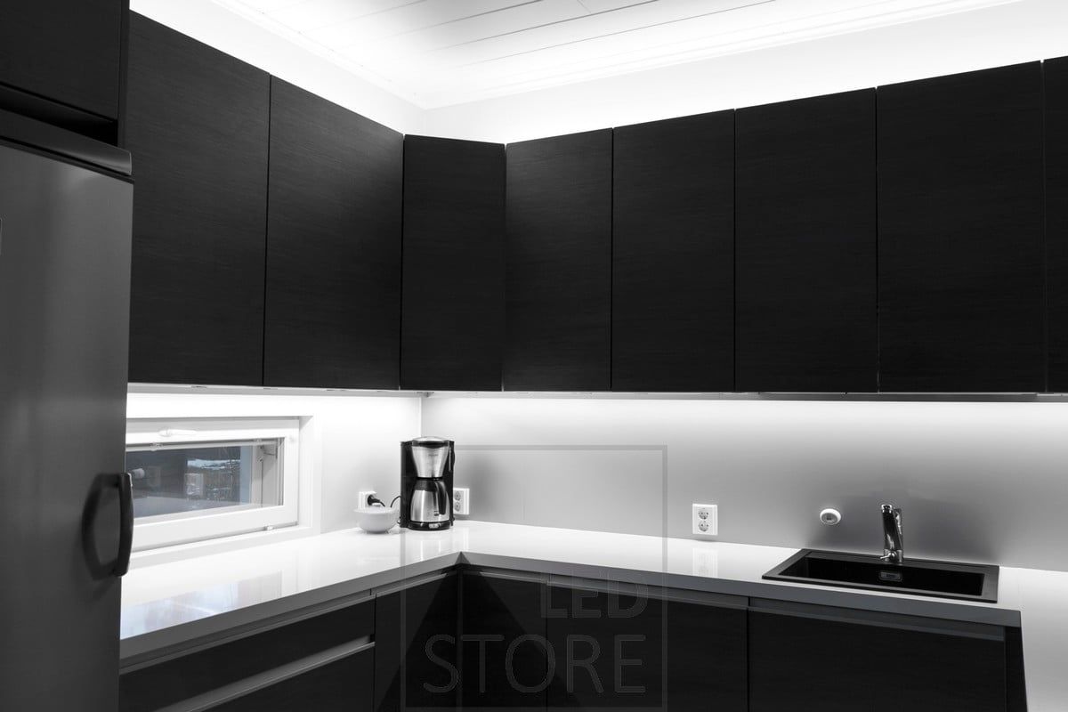 Lighting in the kitchen with led strips on top of the cabinets and attached to the bottom of the cabinets to bring light to the worktop. Ledstore.fi
