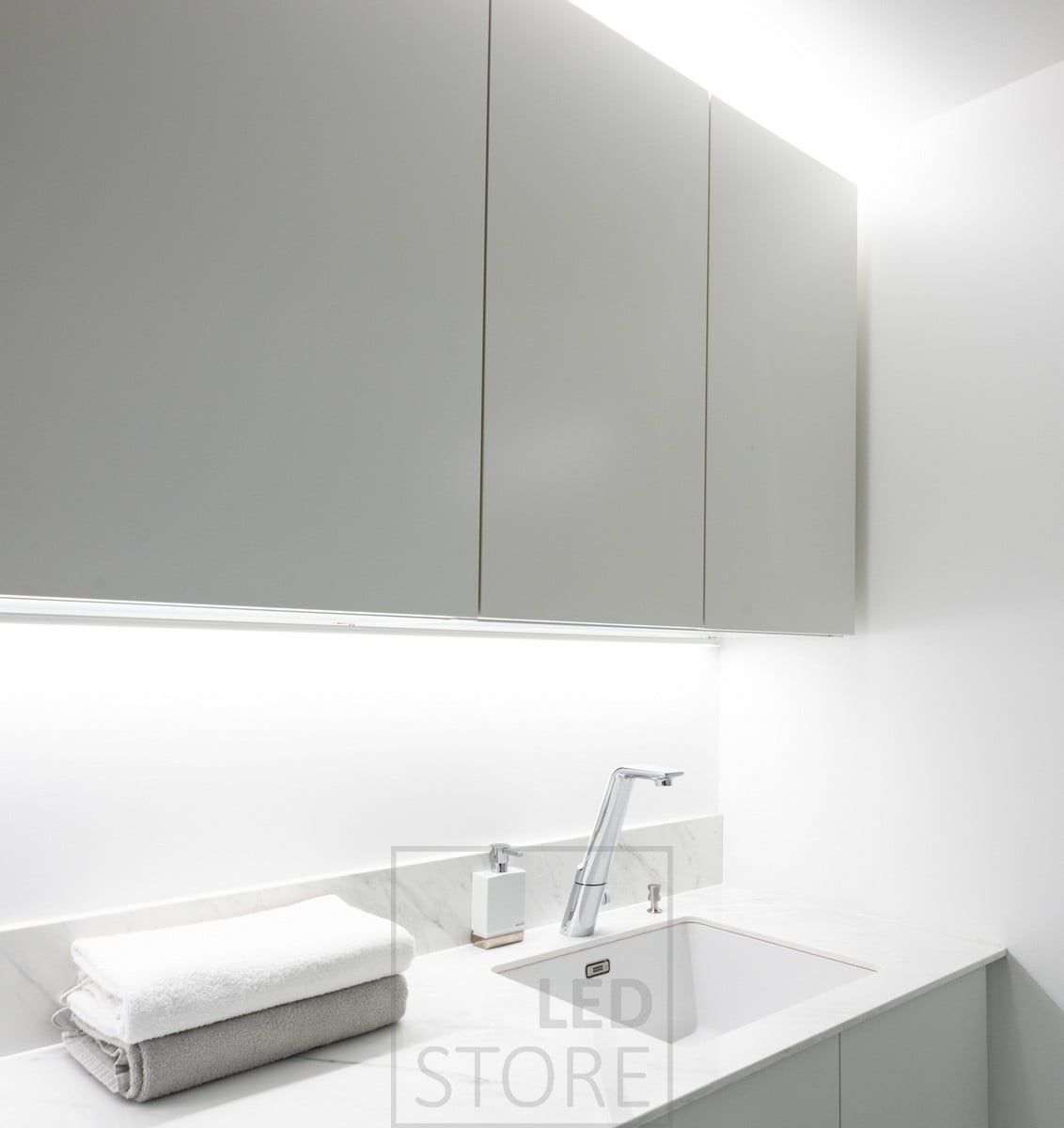 LED strip in the corner to bring light to the level, LED strip on top of the cabinets to create indirect light. Ledstore.fi
