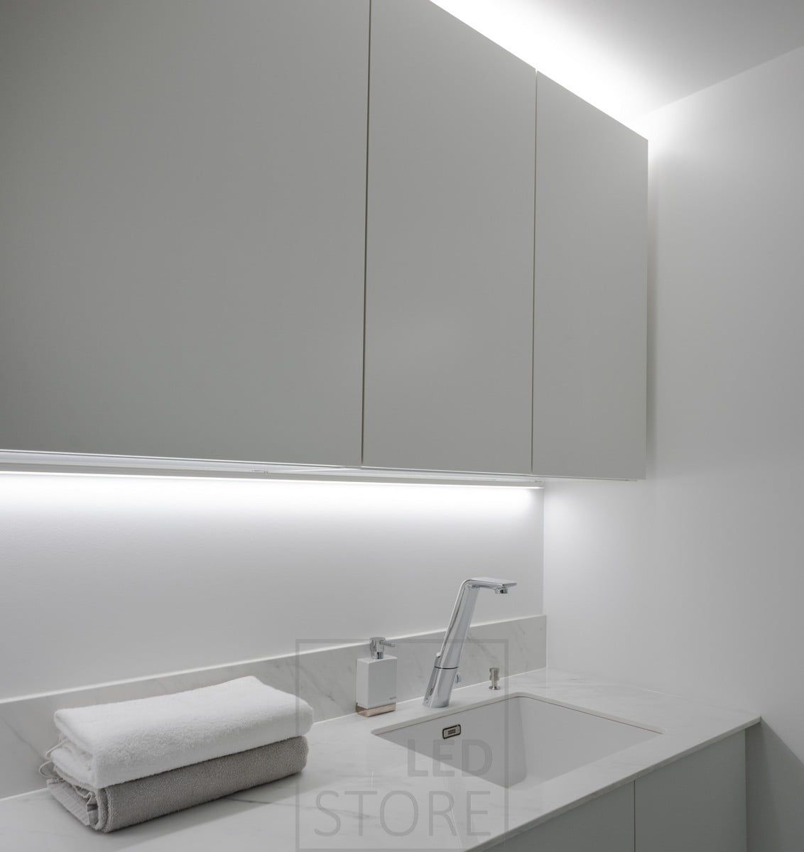 In the utility room, in the corner of the wall and the cupboard, in the surface profile, a led strip provides light on the level, on top of the cupboards, a led strip provides indirect light. Ledstore.fi