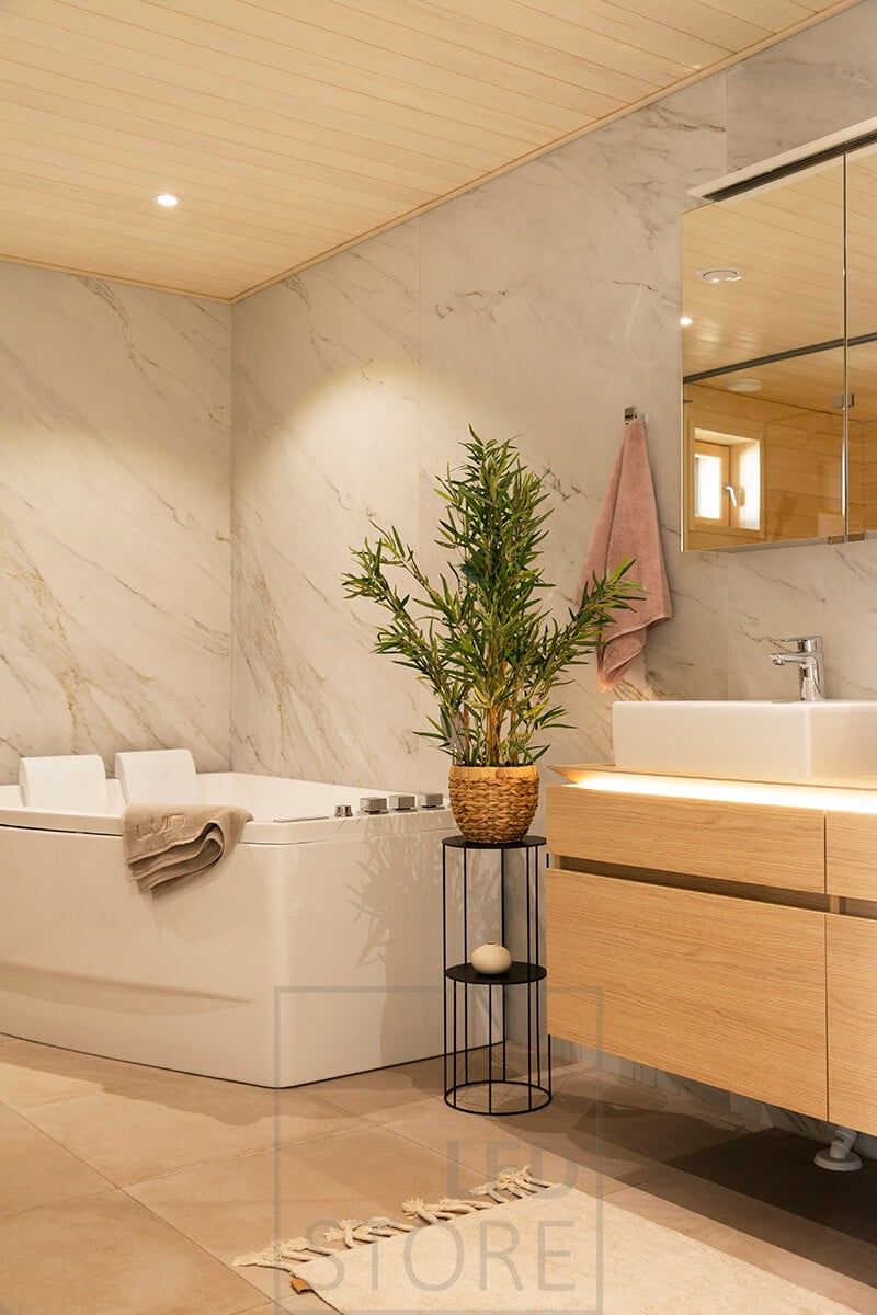 Bathroom spotlight in the ceiling and sink fixture with LED strip milled into the plane to illuminate downwards with soft light. Ledstore.fi