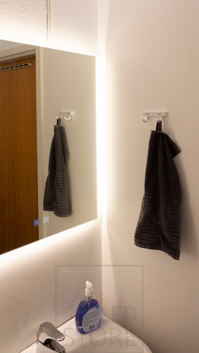 A wall-mounted light mirror illuminates the bathroom with atmospheric indirect light. Ledstore.fi