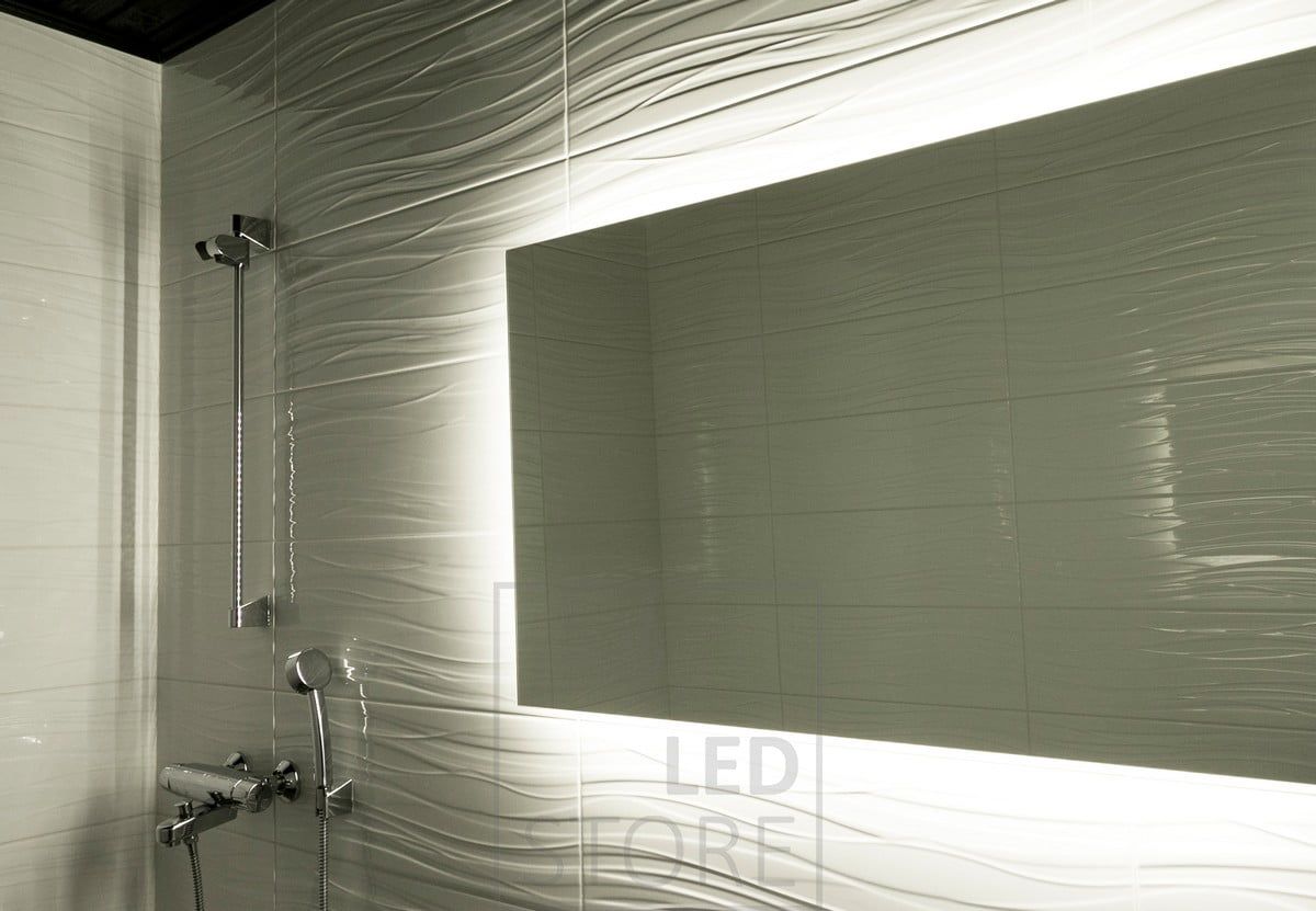 The Led strip, mounted behind the mirror, highlights the patterned tiles and creates a moody indirect light. Ledstore.fi