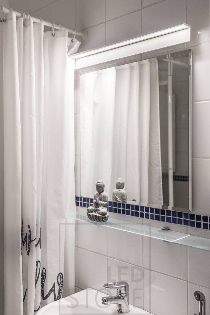 Blade wall light in the bathroom, illuminating the mirror and the face. Ledstore.fi