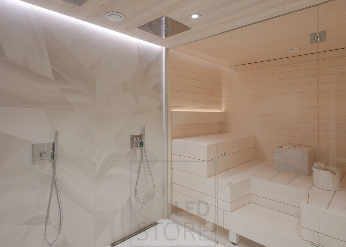 Shower wall accented by a led strip between the ceiling and the wall. In the sauna, a led strip illuminates the back of the backrest. Ledstore.fi