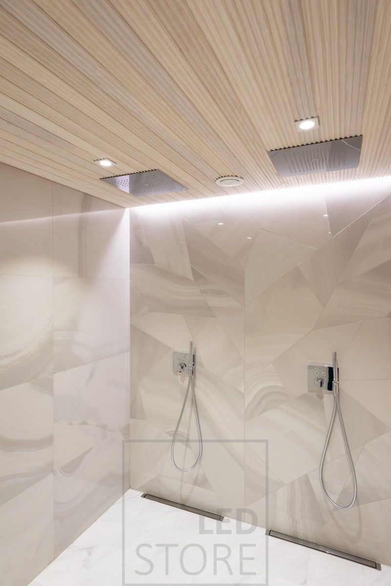 Led strip installed between the ceiling and the wall to highlight the shower wall and the tiling. Two spots in front of the showers to support the strip. Ledstore.fi