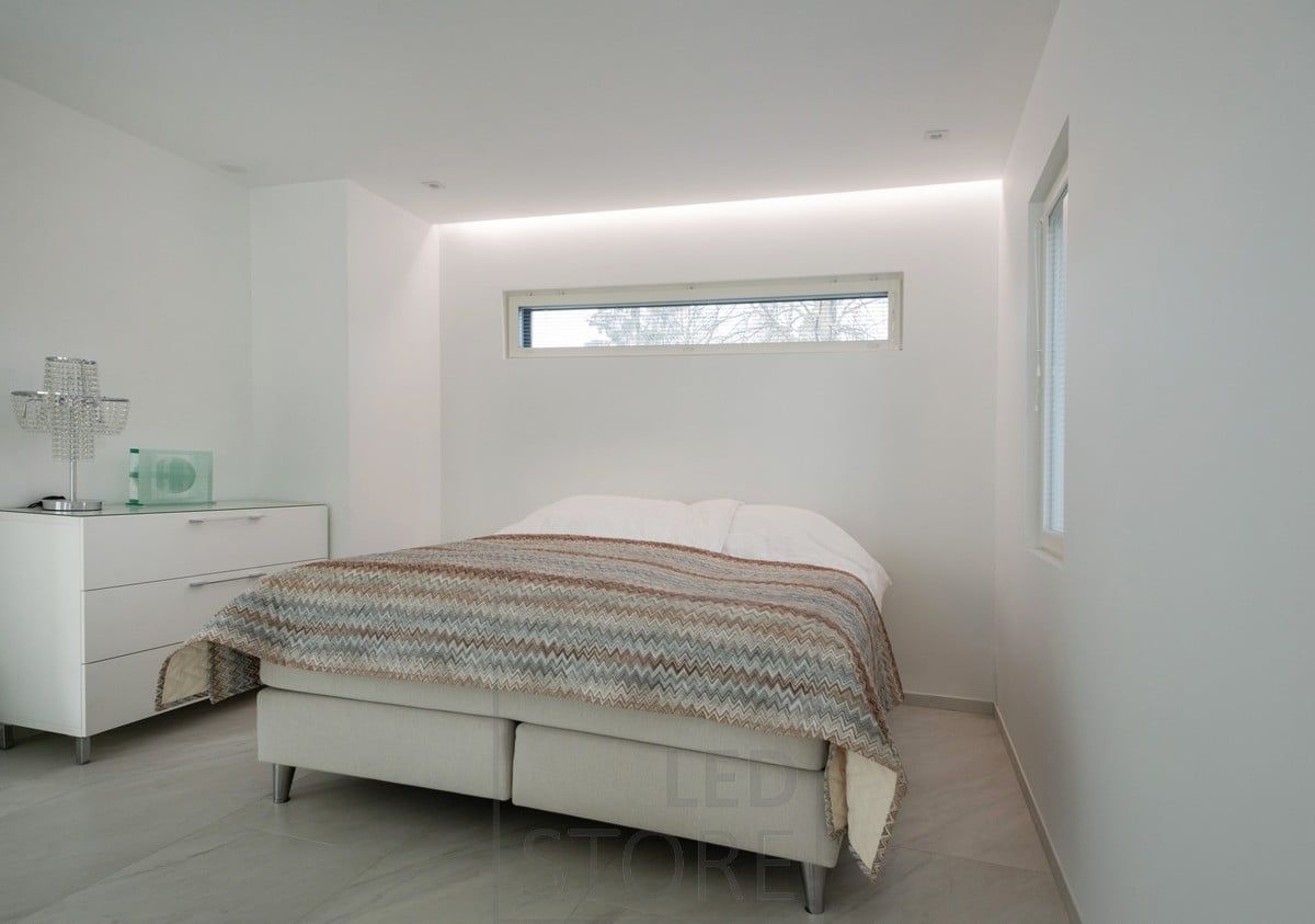 Pleasantly soft mood lighting on the wall behind the bed in the bedroom. Led strip mounted in a groove between the ceiling and the wall. Ledstore.fi