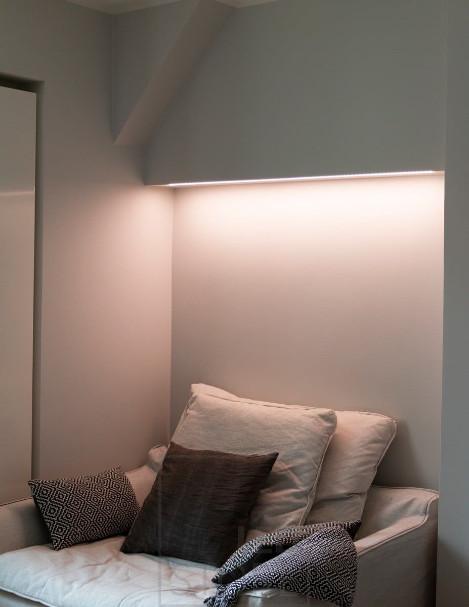 Bedroom with colour temperature adjustable mood lighting behind the bed, LED strip mounted on the bottom of the cabinet in a low profile surface. Ledstore.fi