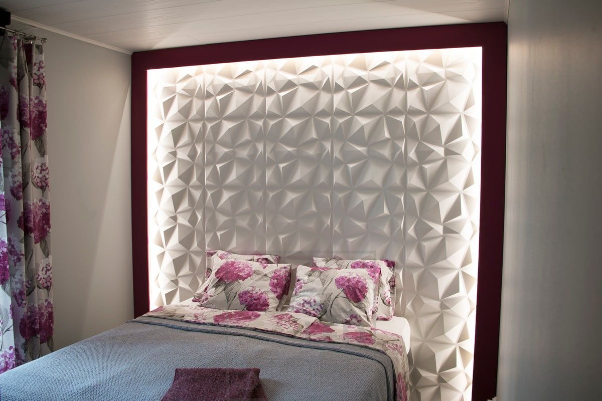 In a bedroom, the texture of a striking bed headboard is accentuated with an LED strip. The led strip illuminates with indirect, soft light. Ledstore.fi