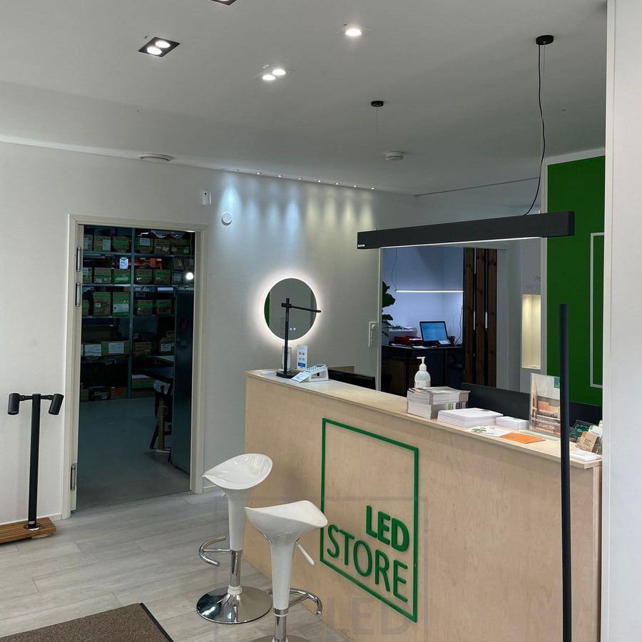 Led lights at Ledstore's showroom. Spots on the ceiling in front of the counter and a VIIVA ceiling light above the counter. The wall is accented by 3W spot sets, fixed and directional. Moon 600 light mirror under the spots. Ledstore.fi