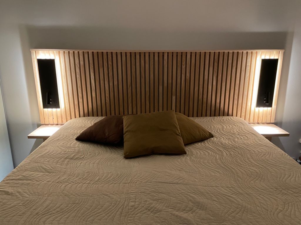 Black NIGHT wall lamps at the head of the bed. The luminaire has a directional reading light and an indirect mood light. Ledstore.fi