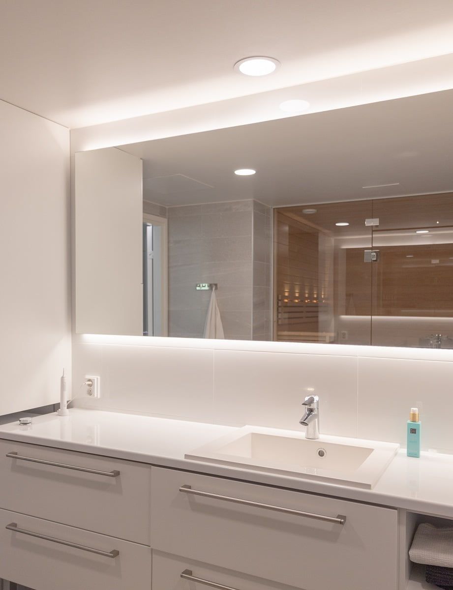 Above the sink, a ceiling light provides a spotlight and a mirror backlight adds indirect light to the space. ©LedStore