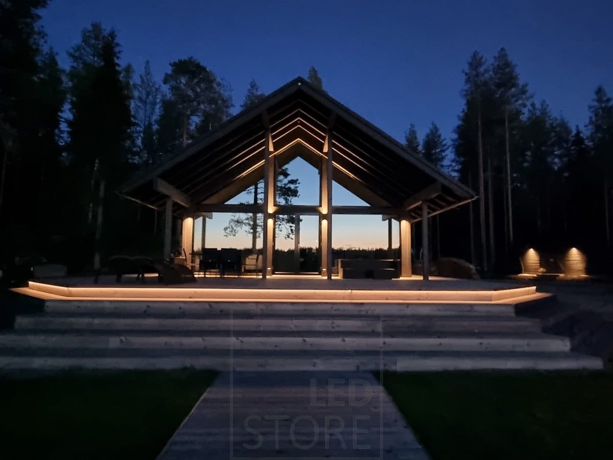 Versatile outdoor lighting implemented with LED strip on the staircase and wall lights. Wall lights illuminating in two directions at a high point, and in one direction at a lower point. Ledstore.fi