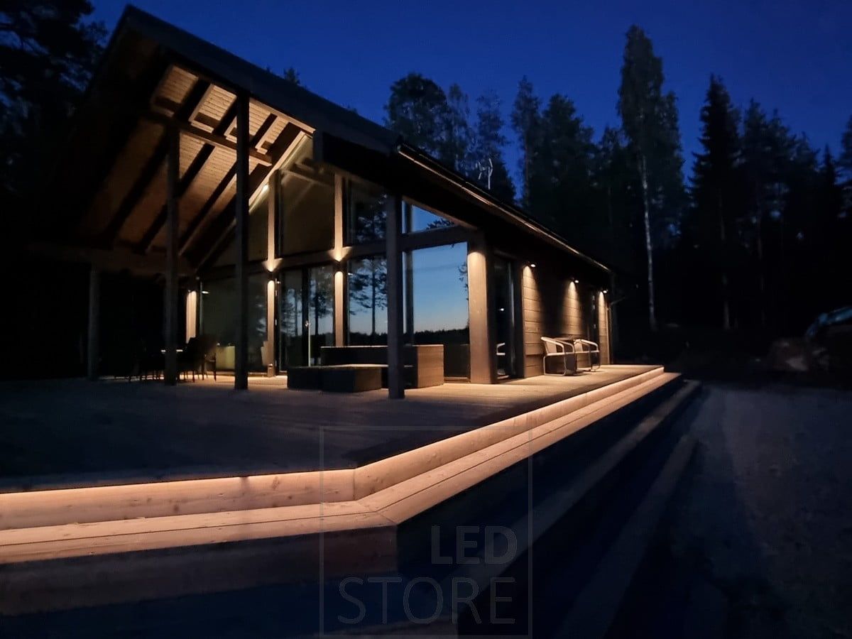 Versatile and atmospheric outdoor lighting with LED strip on the staircase and wall lights. Wall lights illuminating in two directions at a high point, and in one direction at a lower point. Ledstore.fi