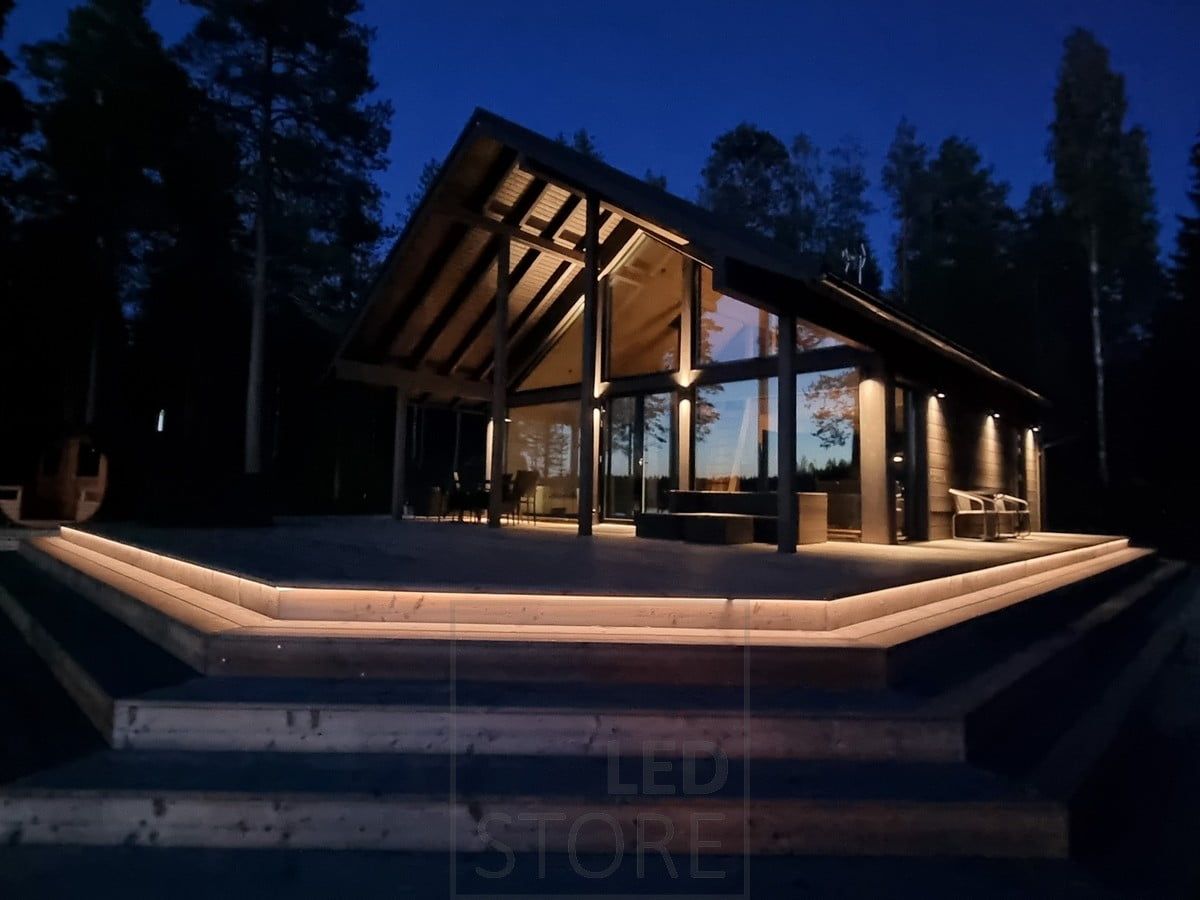 Versatile outdoor lighting implemented with LED strip on the staircase and wall lights. Wall lights illuminating in two directions at the high point, and in one direction at the low point. Ledstore.fi
