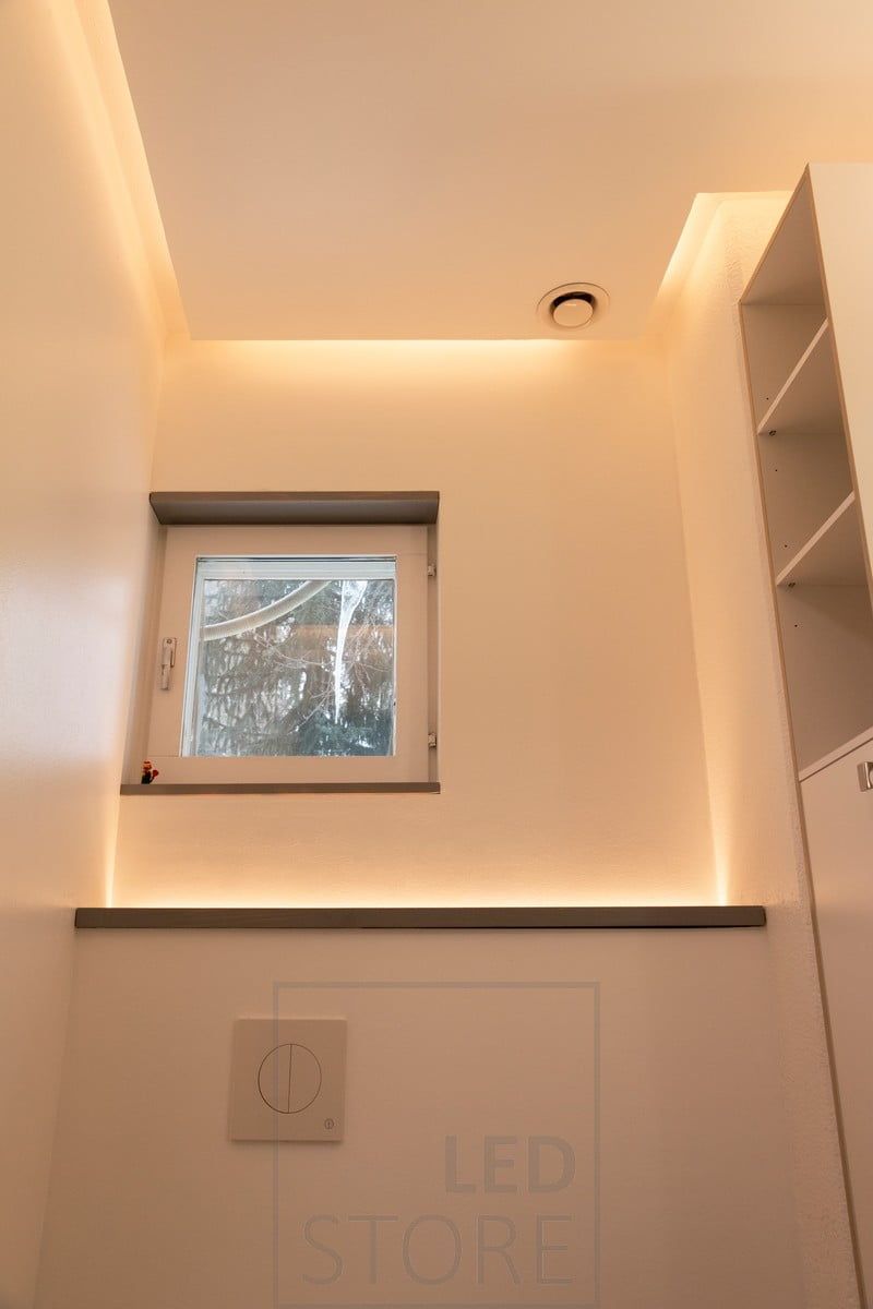 A wall-mounted toilet enclosure with an LED strip facing upwards. Creating an atmospheric light in the space, it is switched on by a motion sensor so it also works well as a night light. On the ceiling in the drop down led strip directed at the wall. Ledstore.fi