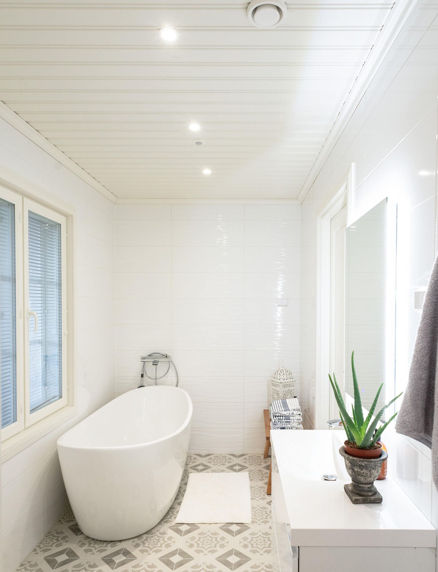 Spotlights on the bathroom ceiling and a light mirror illuminating the sink.