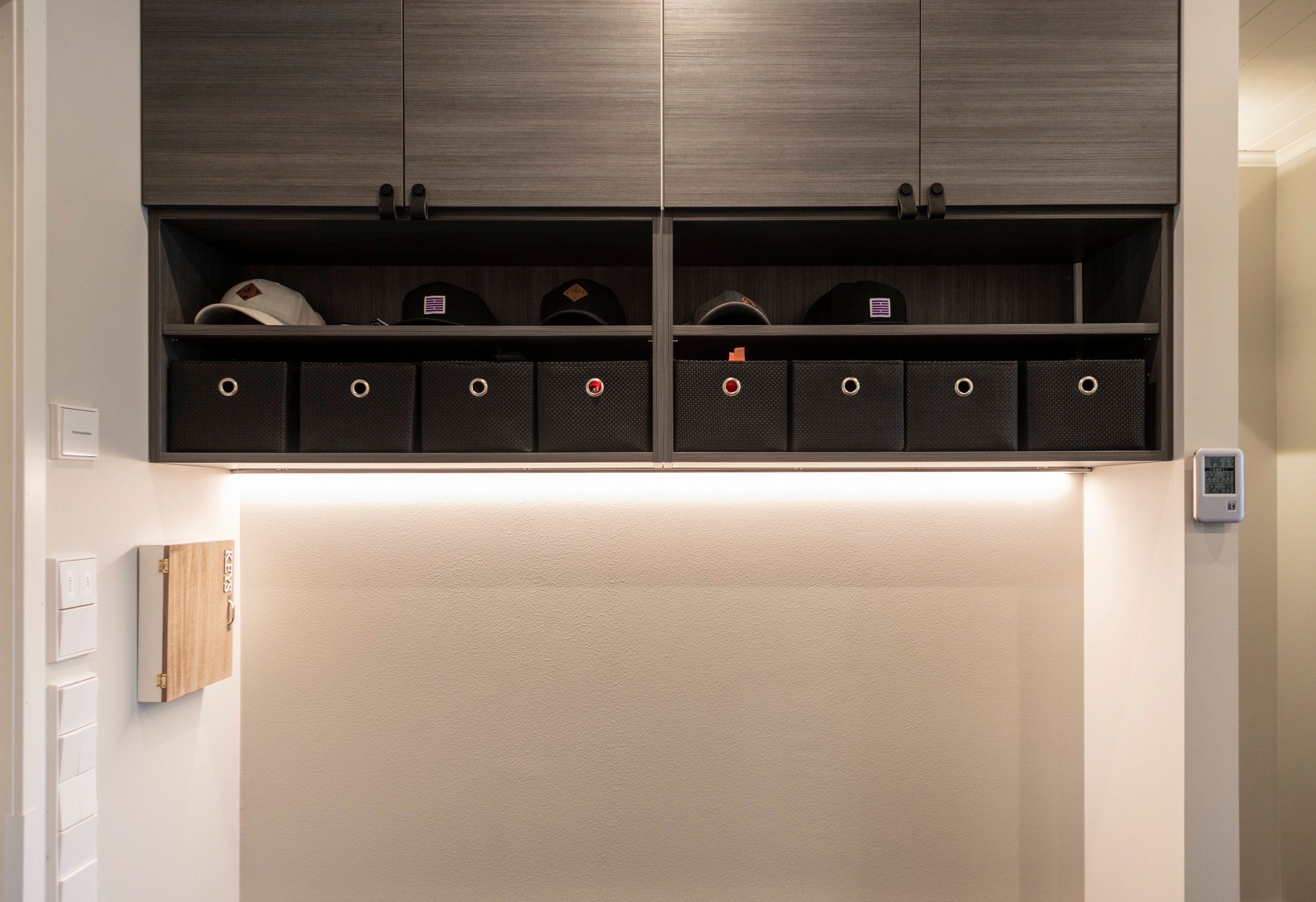 At the bottom of the upper cabinet in the hallway, an LED strip in a low profile surface indirectly illuminates the ambient light. Ledstore.fi