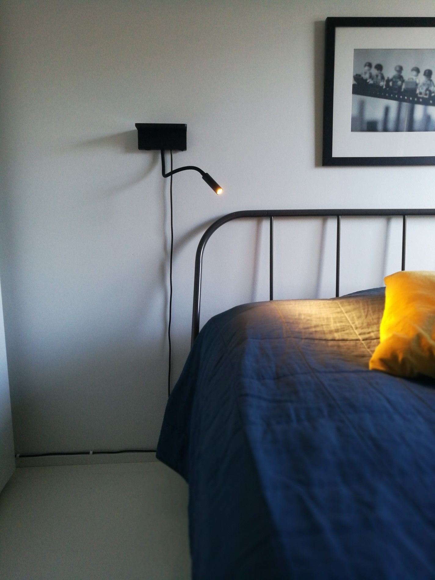 NIGHT BLADE lamp on the wall next to the bed, illuminated