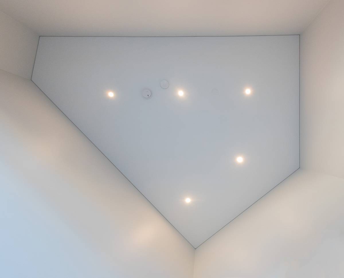 Led spots on the ceiling, seen directly from below. The layout of the spots can be adapted to the shape of the space, as in this five-edged space. 