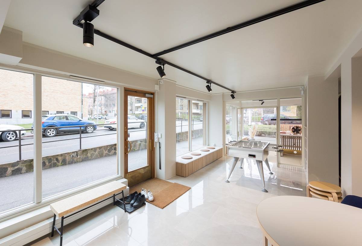 Office with light surfaces, black three-phase track on the ceiling with four black spotlights.