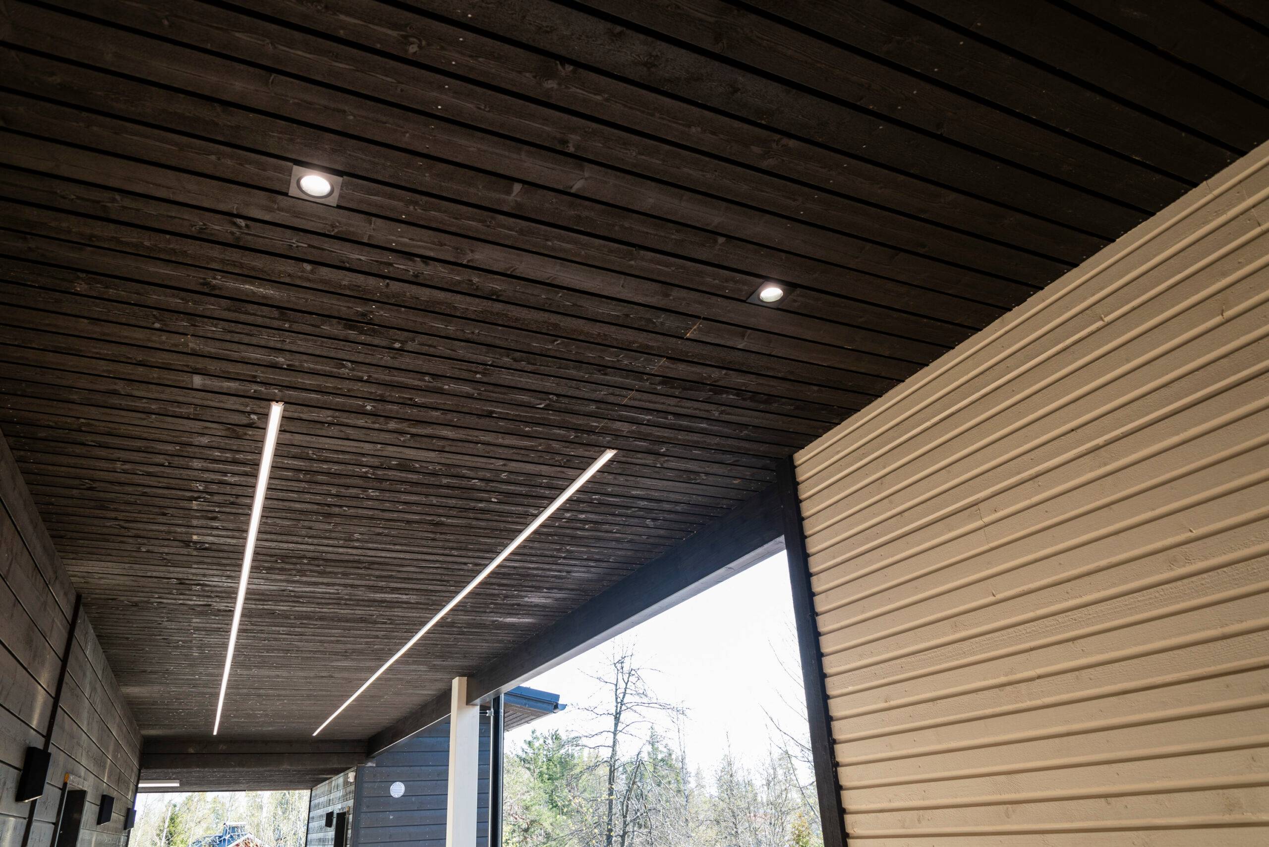In the entrance corridor, the passage is illuminated by two long LED strip lights in parallel. There are also two recessed LED spotlights and additional wall lights on the wall.