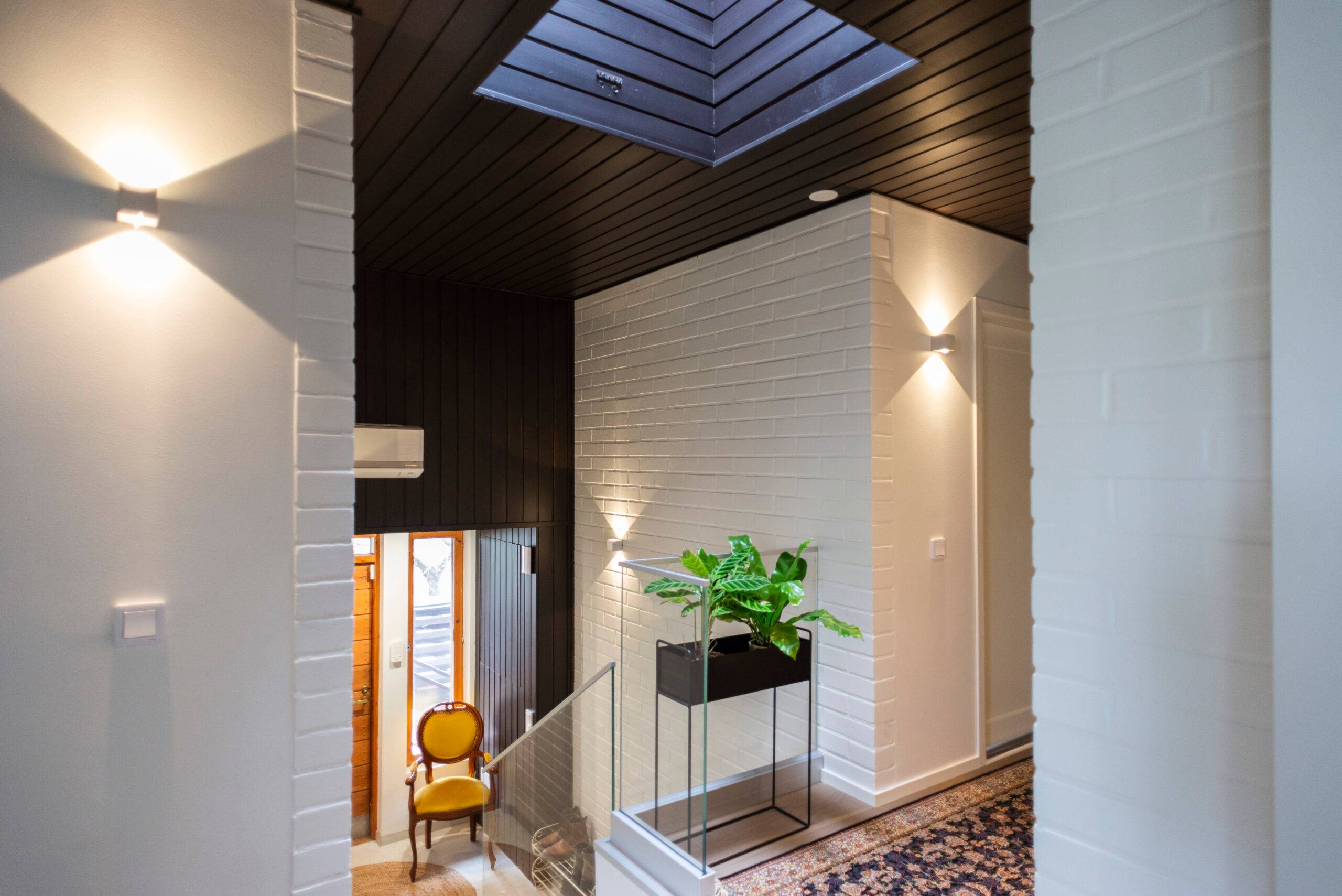 In the renovation project, designated spots and control switches for three LED wall lights were already in place on the brick wall.