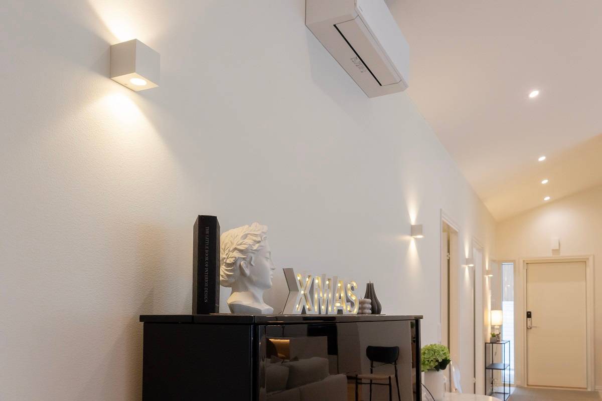 A modern living room with stylish wall lights from LedStore.fi, black cabinetry, interior accessories and a wall-mounted air conditioner - one of our latest 2025 reference projects.