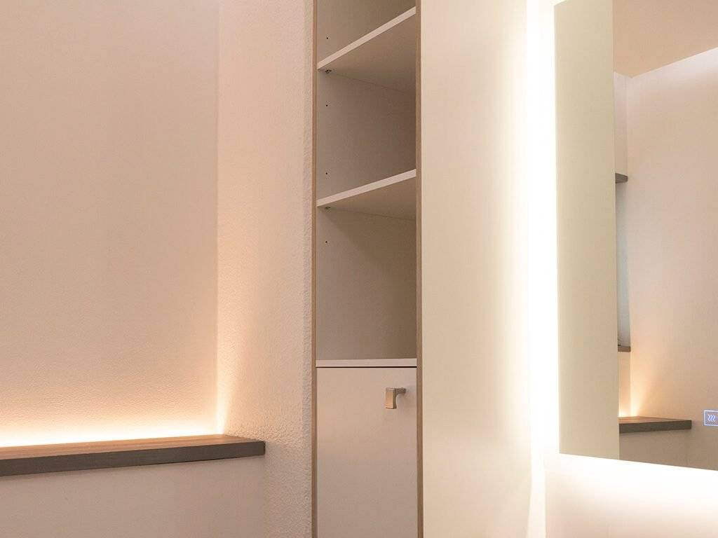 LED-lit shelves, mirrored wall, soft lighting. Neutral colors and clean lines.